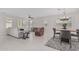 Open-concept living room and dining area featuring stylish furniture and neutral tile flooring at 1272 W Camina Buena Vis, Queen Creek, AZ 85140