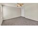 Spacious bedroom featuring a ceiling fan, plush carpeting, and ample natural light from multiple windows at 15802 W Watson Ln, Surprise, AZ 85379