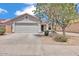 Front view showcasing a two-car garage and desert landscaping at 15802 W Watson Ln, Surprise, AZ 85379