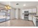 Bright kitchen with white cabinets, stainless steel appliances, and a sliding glass door to the patio at 15802 W Watson Ln, Surprise, AZ 85379