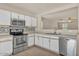 Well-lit kitchen showcasing stainless steel appliances, white cabinets, and an open layout at 15802 W Watson Ln, Surprise, AZ 85379