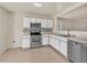 Spacious kitchen features stainless steel appliances, white cabinets, and tile backsplash at 15802 W Watson Ln, Surprise, AZ 85379