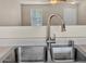 Close-up of a stainless steel kitchen sink with a modern faucet and neutral countertops at 15802 W Watson Ln, Surprise, AZ 85379