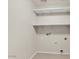 The laundry room includes built-in shelving, tile flooring, and utility connections for washer and dryer hookups at 15802 W Watson Ln, Surprise, AZ 85379