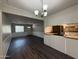 Eat-in kitchen with dark flooring, a chandelier, and white cabinets for a light and airy feel at 1723 W Cheryl Dr, Phoenix, AZ 85021