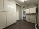 A laundry room with modern cabinetry, gray walls, and dark wood-look flooring at 1723 W Cheryl Dr, Phoenix, AZ 85021