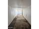 Inside a narrow storage room with concrete flooring, a single door lets light in at 1723 W Cheryl Dr, Phoenix, AZ 85021
