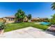 Spacious backyard features a well-maintained lawn, mature trees, and a sparkling pool at 18658 N Tanners Way, Maricopa, AZ 85138