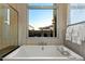 Soaking tub with fixtures and window views, complemented by decorative soaps and plush towels at 19917 E Natalie Way, Queen Creek, AZ 85142