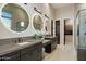 Bright bathroom with double sinks, backlit mirrors, and tiled walls leading to a glass shower at 19917 E Natalie Way, Queen Creek, AZ 85142