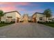 Expansive driveway leading to a luxury home with attached garages and stone accents under a beautiful sunset at 19917 E Natalie Way, Queen Creek, AZ 85142