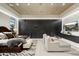A luxurious bedroom featuring a unique accent wall, modern lighting, and a cozy seating area for relaxation at 19917 E Natalie Way, Queen Creek, AZ 85142