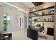 A modern home office design featuring a glass wall, built-in shelving, and natural light from the exterior at 19917 E Natalie Way, Queen Creek, AZ 85142