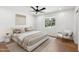 Bright bedroom featuring a ceiling fan, wood floors, and backyard views from the window at 20 W Pasadena Ave, Phoenix, AZ 85013