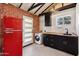 Modern laundry room featuring black cabinetry, butcher block countertops, red refrigerator, and a washer at 20 W Pasadena Ave, Phoenix, AZ 85013