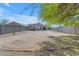 Expansive backyard featuring a large dirt area, gray block fence, and desert landscaping at 2028 W Alice Ave, Phoenix, AZ 85021