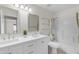 Bright bathroom with a double vanity, two mirrors, and a separate tub and shower at 2028 W Alice Ave, Phoenix, AZ 85021