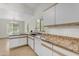 Bright kitchen features white cabinets, granite countertops and island with sink at 2028 W Alice Ave, Phoenix, AZ 85021