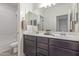 Elegant bathroom featuring a dual sink vanity, a large mirror, and a convenient shower at 22876 E Via Del Sol --, Queen Creek, AZ 85142