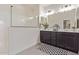 Modern bathroom featuring a dual sink vanity with dark cabinets and a walk-in shower with glass enclosure at 22876 E Via Del Sol --, Queen Creek, AZ 85142