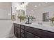 Bright bathroom with dual sinks, dark cabinetry, white countertops, and decorative floral arrangements at 22876 E Via Del Sol --, Queen Creek, AZ 85142