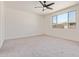 Light-filled bedroom with ceiling fan, large window, and neutral carpet flooring at 22876 E Via Del Sol --, Queen Creek, AZ 85142
