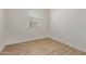 Minimalist bedroom featuring wood flooring and a window with blinds, providing natural light at 22876 E Via Del Sol --, Queen Creek, AZ 85142