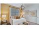 Cozy bedroom featuring decorative pillows and blanket, modern light fixture, and soothing artwork at 24063 W Cocopah St, Buckeye, AZ 85326