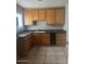 An efficient kitchen featuring tile floors, wood cabinets, and black countertops at 25 W Illini St, Phoenix, AZ 85041