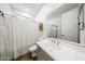 Well-lit bathroom with a white vanity, neutral color palette, and shower with patterned curtain at 25051 N 140Th Dr, Surprise, AZ 85387