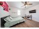 Well-lit bedroom features a ceiling fan, cozy bed, and desk area for study or work at 25051 N 140Th Dr, Surprise, AZ 85387
