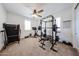 Bright bedroom featuring exercise equipment, neutral walls, carpet, and plantation shutters at 25051 N 140Th Dr, Surprise, AZ 85387