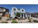 Beautiful two-story home with a light blue exterior, grey shutters, and desert landscaping at 25051 N 140Th Dr, Surprise, AZ 85387