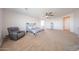 A spacious main bedroom featuring a ceiling fan, carpeted floors and a comfortable recliner at 25051 N 140Th Dr, Surprise, AZ 85387