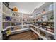 Spacious walk-in pantry with ample shelving for organized storage and wood look flooring at 25051 N 140Th Dr, Surprise, AZ 85387