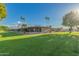 Backyard view of the building with grassy lawn, mature trees, and manicured landscaping at 25225 S Glenburn Dr, Sun Lakes, AZ 85248