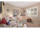 Well-decorated bedroom featuring a daybed with floral pillows, a seating area, and shutters at 25225 S Glenburn Dr, Sun Lakes, AZ 85248