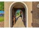 Charming courtyard entrance features a white brick archway with a vintage table and bench at 25225 S Glenburn Dr, Sun Lakes, AZ 85248