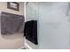 Close up on the frosted glass shower door with black and gray towels on a white towel bar at 25225 S Glenburn Dr, Sun Lakes, AZ 85248