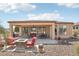 Charming backyard oasis with patio, cozy fire pit, outdoor grill, and desert landscaping at 27023 N 130Th Gln, Peoria, AZ 85383