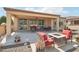 Well-designed covered patio with comfortable seating, a fire pit, and desert landscaping at 27023 N 130Th Gln, Peoria, AZ 85383