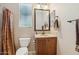 Bathroom features a sink with storage, a mirror, and a toilet at 27023 N 130Th Gln, Peoria, AZ 85383