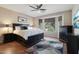Bright main bedroom with a large bed, a ceiling fan, and bay windows that let in natural light at 27023 N 130Th Gln, Peoria, AZ 85383