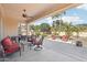 Covered patio with ceiling fan, outdoor seating, and views of the manicured backyard at 27023 N 130Th Gln, Peoria, AZ 85383