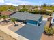 Aerial shot of a blue home featuring a large driveway, desert landscaping, and a well-maintained exterior at 2708 E Villa Theresa Dr, Phoenix, AZ 85032