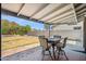 The covered patio leads to a lush backyard with a table and chairs set and a grassy lawn at 2708 E Villa Theresa Dr, Phoenix, AZ 85032