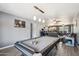 Spacious living room featuring wood-look floors, neutral paint, a pool table, and open access to the kitchen at 2708 E Villa Theresa Dr, Phoenix, AZ 85032