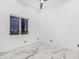 Bright bedroom with white walls, modern ceiling fan and striking marble floors at 3518 N 201St Ln, Buckeye, AZ 85396