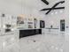 Bright kitchen featuring marble floors, island with black cabinetry, modern appliances and hanging lights at 3518 N 201St Ln, Buckeye, AZ 85396
