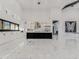 Spacious kitchen with white cabinetry, black island, marble floors, and modern stainless steel appliances at 3518 N 201St Ln, Buckeye, AZ 85396